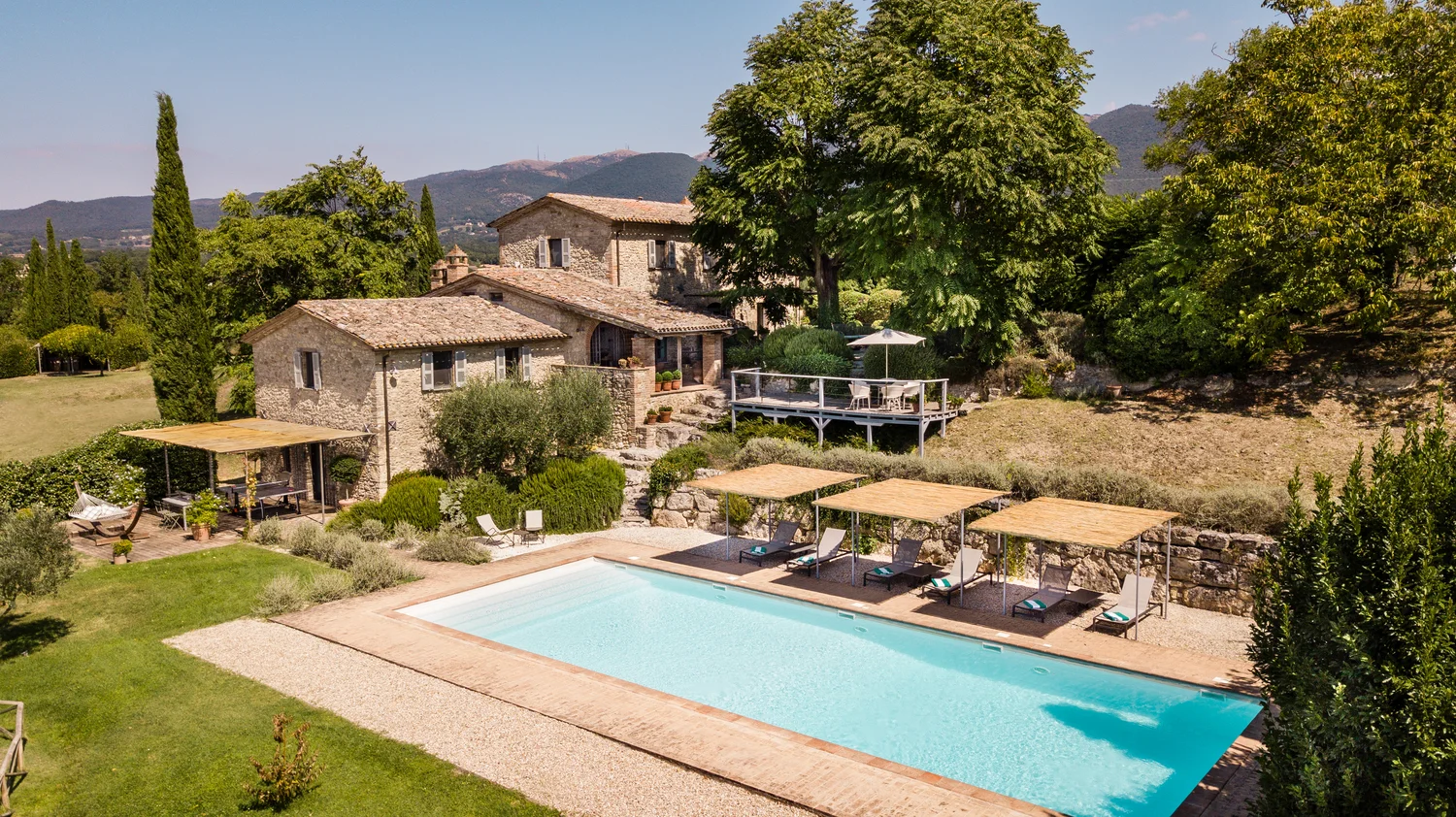 Casale Del Sole seen from above with its lawn, pool and surrounding countryside