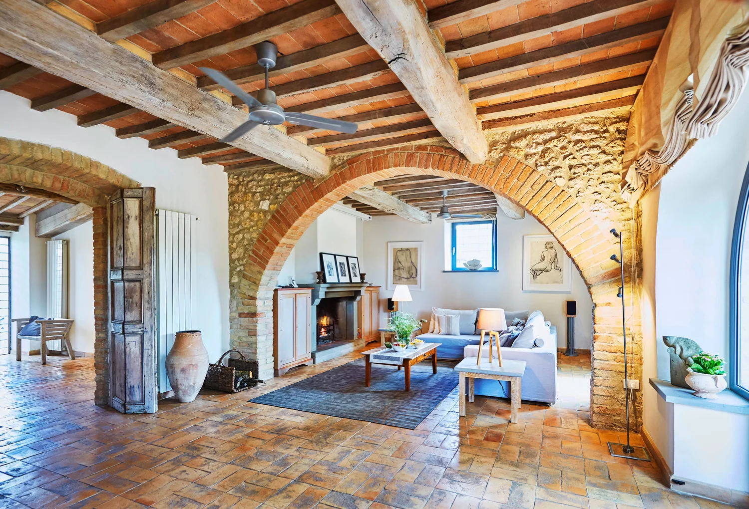Living room with stone archway, fireplace and exposed beams