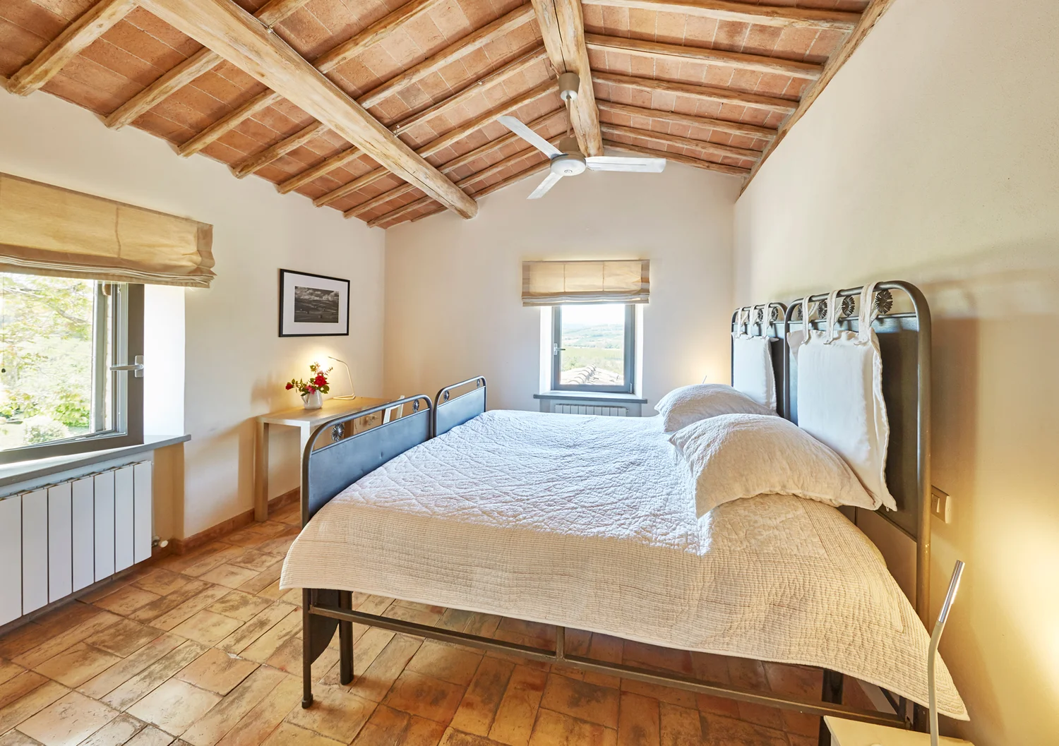 Third bedroom with white linens and beamed ceiling