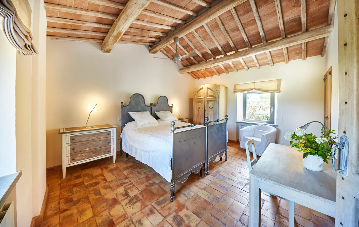 Twin bedroom with antique metal beds and shuttered windows